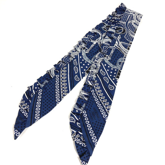 HERMES Apron d'Or, a silk scarf with a ruffled twilly lining, available in Marine Foncé, black, white, and blue.